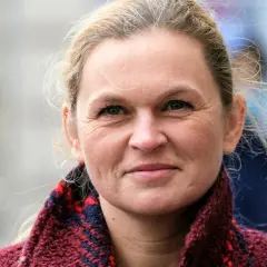 Barbara Nowacka, z uśmiechem na twarzy, w wieku, który świadczy o doświadczeniu życiowym.