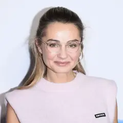 Małgorzata Socha w okularach, z subtelnym uśmiechem. Jej wiek dodaje jej uroku i doświadczenia.