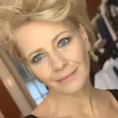 Kobieta z niebieskimi oczami i blond włosami, uśmiecha się. W tle widać ubrania. Ile lat ma Kożuchowska?