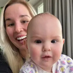Uśmiechnięta blondynka z dzieckiem na rękach. Dziecko ma ok. 1 roku, a jego wiek to ile lat ma lil masti.