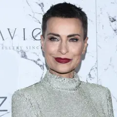 Danuta Stenka, wiek nie gra roli, gdy ma się taki styl. Aktorka w błyszczącej kreacji na tle marmurowej ściany z logo SAVICKI.