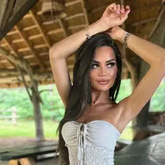 Ania Kokocińska, w wieku, w letniej stylizacji, pozuje pod drewnianą altaną.