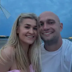 Klaudia z Rolnik szuka żony i jej partner uśmiechają się do zdjęcia na tle morza i wiatraka.