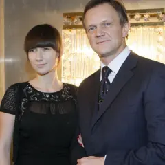 Cezary Pazura z żoną, Edytą Pazurą, pozują do zdjęcia w eleganckich strojach.