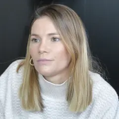 Maja Bohosiewicz w swetrze z golfem i złotymi kolczykami, zamyślona.