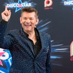 Uśmiechnięty Zenek Martyniuk w błyszczącej marynarce, pozuje na tle logo Polo TV. Ciekawe, ile lat ma Zenek Martyniuk?
