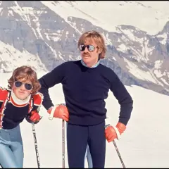 Robert Redford i jego dzieci na stoku narciarskim, w tle ośnieżone góry.