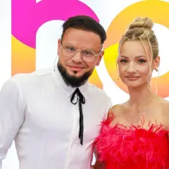 Para fit lovers, ile lat mają? Ona w różowej sukience, on w białej koszuli.