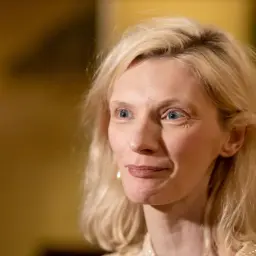 Agata Buzek zamyślona, jakby wspominała swoje dzieci. Jej spojrzenie jest ciepłe, a uśmiech subtelny.