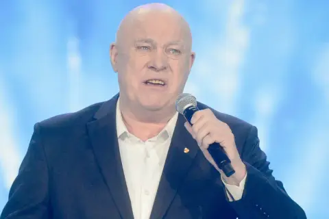 Ryszard Rynkowski, znany artysta, śpiewa do mikrofonu. Jego wiek nie przeszkadza mu w karierze.