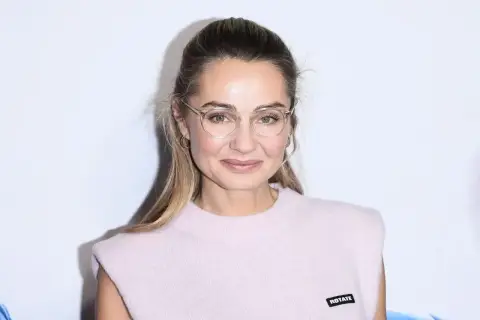 Małgorzata Socha w okularach, z subtelnym uśmiechem. Jej wiek dodaje jej uroku i doświadczenia.