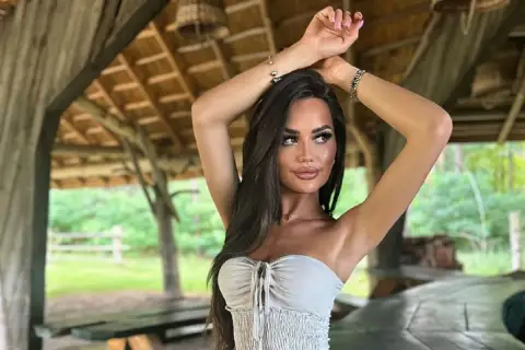 Ania Kokocińska, w wieku, w letniej stylizacji, pozuje pod drewnianą altaną.