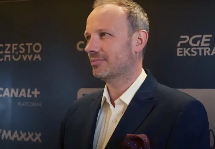Marcin Majewski z TVN w eleganckim garniturze, na tle logotypów PGE Ekstraklasa i Canal+.