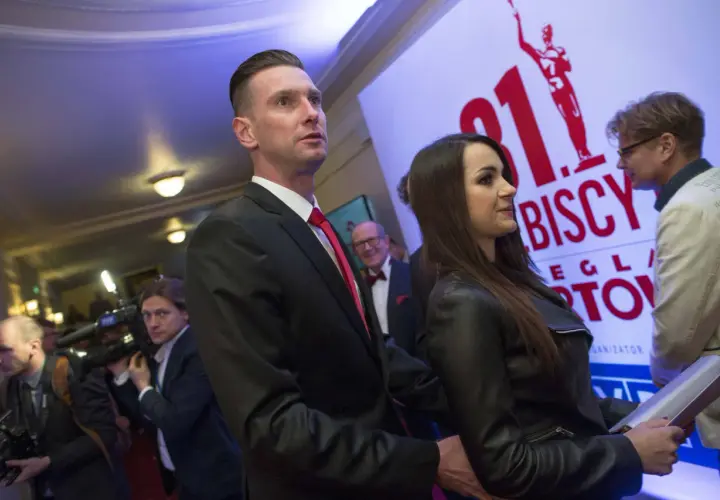 Barbara Gołąb Kadziewicz w czarnej ramonesce obok mężczyzny w garniturze, na tle baneru z napisem "31. Biscy".