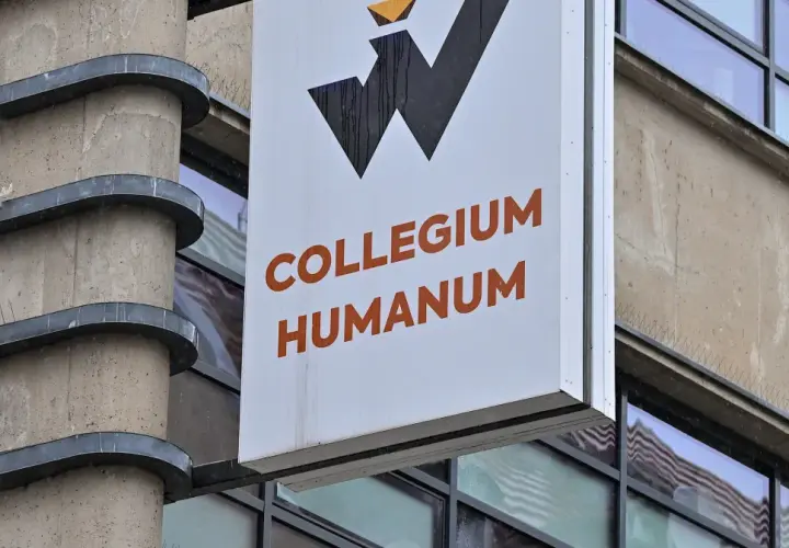 Tablica z napisem Collegium Humanum, budynek o surowej architekturze, w tle odbicia, które mogą sugerować aferę.