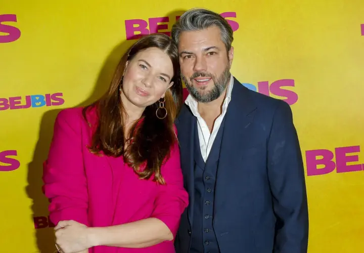 Karolina Malinowska Janiak i jej partner pozują na tle żółtej ścianki z napisem "BEJBIS".