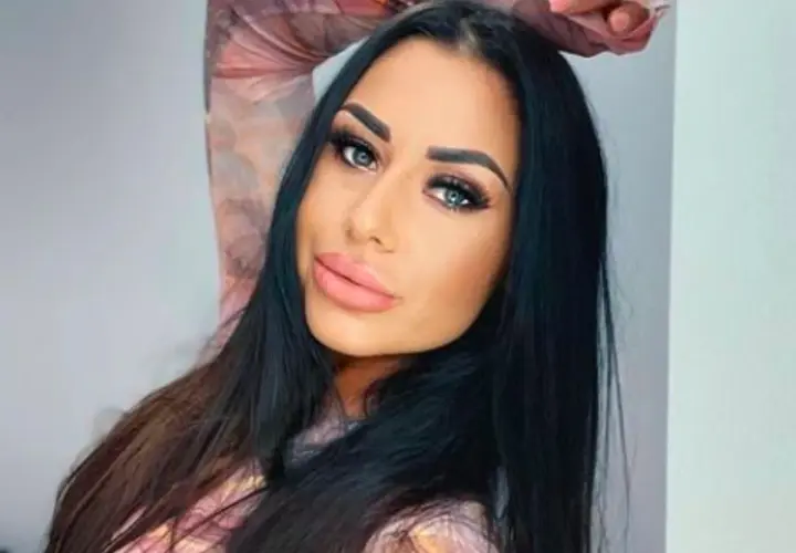 Stella z Love Island, z długimi czarnymi włosami i wyrazistym makijażem, pozuje do zdjęcia.