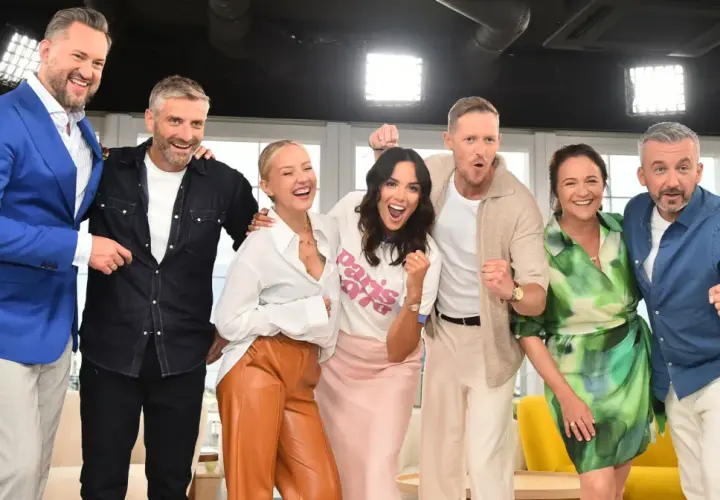 Uśmiechnięci dziennikarze i prezenterzy TVN pozują do zdjęcia, świętując sukces.