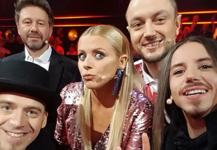 Uśmiechnięci jurorzy Voice of Poland w barwnych strojach, gotowi oceniać talenty.