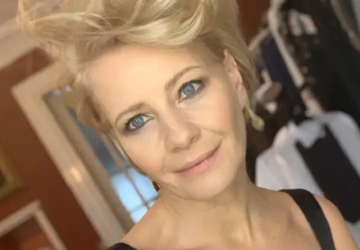 Kobieta z niebieskimi oczami i blond włosami, uśmiecha się. W tle widać ubrania. Ile lat ma Kożuchowska?