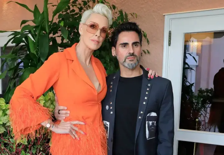 Brigitte Nielsen z mężem, Mattem. Ona w pomarańczowej kreacji z piórami, on w ozdobnej marynarce.