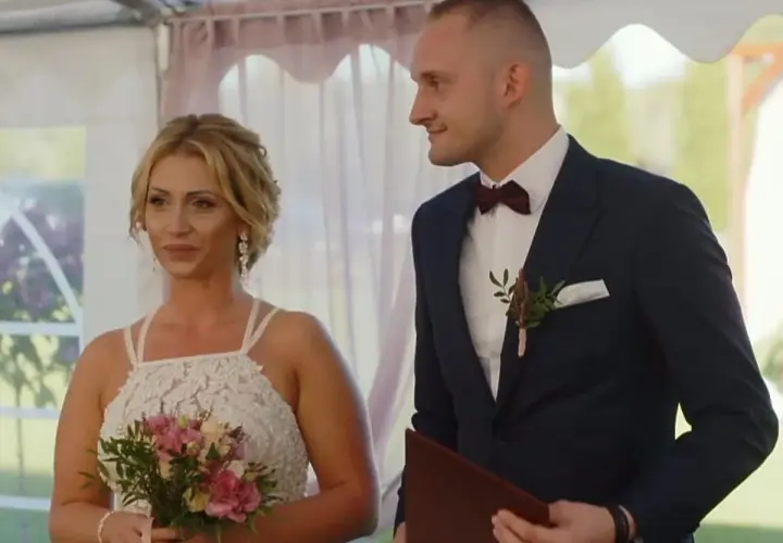 Iza i Kamil, ślub od pierwszego wejrzenia. Panna młoda z bukietem, pan młody w garniturze, patrzą na siebie z uśmiechem.