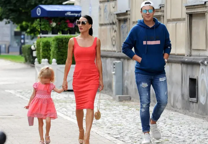 Justyna Steczkowska z córką i synem spacerują ulicą. Piosenkarka ma na sobie czerwoną sukienkę, a jej dzieci są ubrane w kolorowe ubrania.