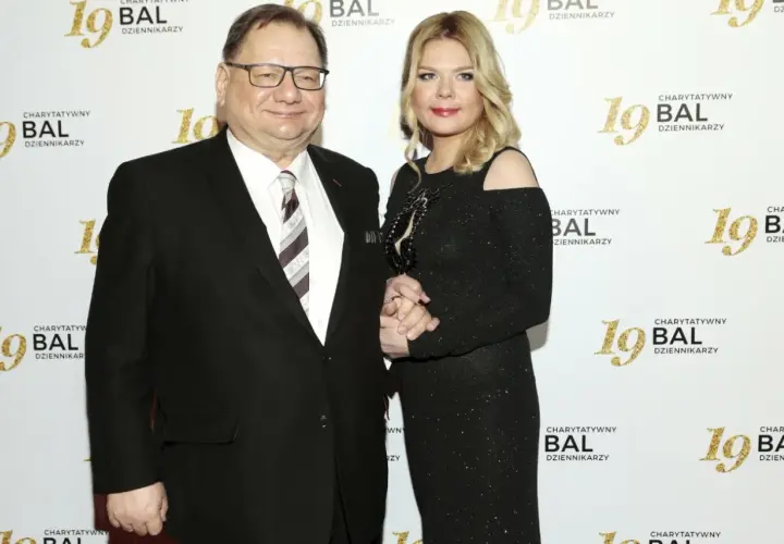Dominika Lis, w wieku około 40 lat, w czarnej, błyszczącej sukni, stoi obok starszego mężczyzny w garniturze.
