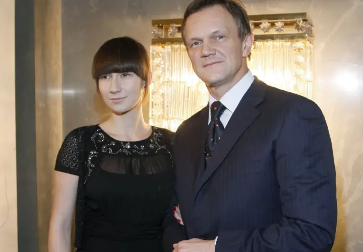 Cezary Pazura z żoną, Edytą Pazurą, pozują do zdjęcia w eleganckich strojach.