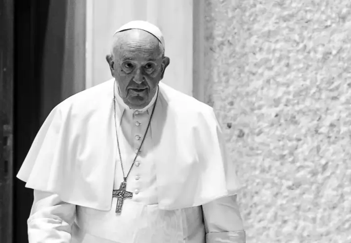 Papież Franciszek, mimo swojego wieku, z uwagą spogląda przed siebie. W białej sutannie i z krzyżem na szyi.