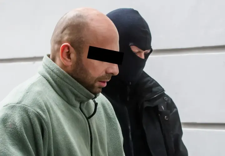 Krystek Sopot, w zielonym polarze, z zakrytą twarzą, obok niego mężczyzna w kominiarce.