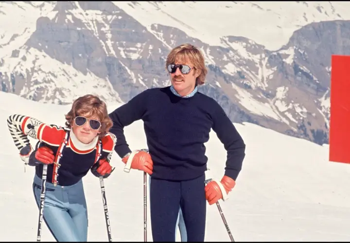 Robert Redford i jego dzieci na stoku narciarskim, w tle ośnieżone góry.