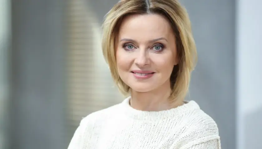 Jolanta Pieńkowska w białym swetrze, z uśmiechem na twarzy. Spekulacje o jej operacje plastyczne krążą od lat.