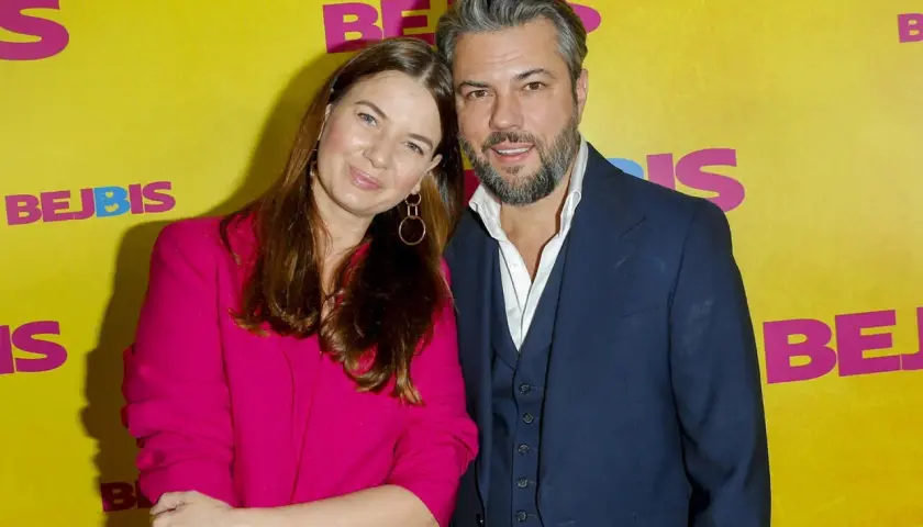 Karolina Malinowska Janiak i jej partner pozują na tle żółtej ścianki z napisem "BEJBIS".