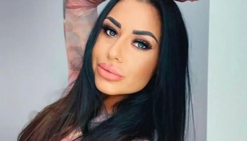 Stella z Love Island, z długimi czarnymi włosami i wyrazistym makijażem, pozuje do zdjęcia.