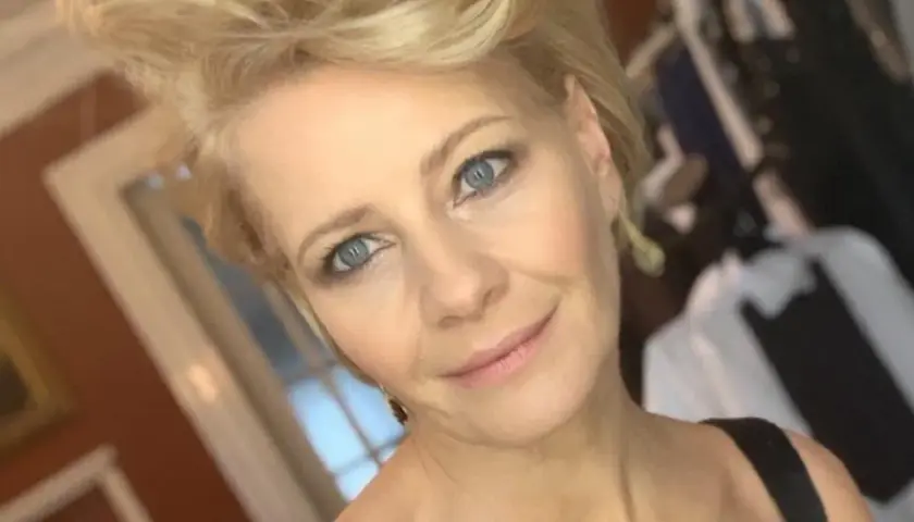 Kobieta z niebieskimi oczami i blond włosami, uśmiecha się. W tle widać ubrania. Ile lat ma Kożuchowska?