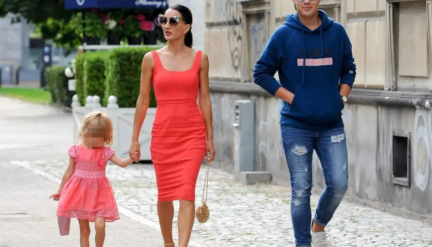 Justyna Steczkowska z córką i synem spacerują ulicą. Piosenkarka ma na sobie czerwoną sukienkę, a jej dzieci są ubrane w kolorowe ubrania.