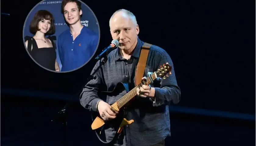 Kuba Sienkiewicz gra na gitarze, a w tle widać jego dzieci.