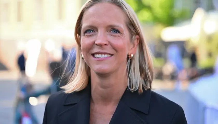 Uśmiechnięta Małgorzata Trzaskowska, której wykształcenie jest szeroko komentowane, w czarnym żakiecie.