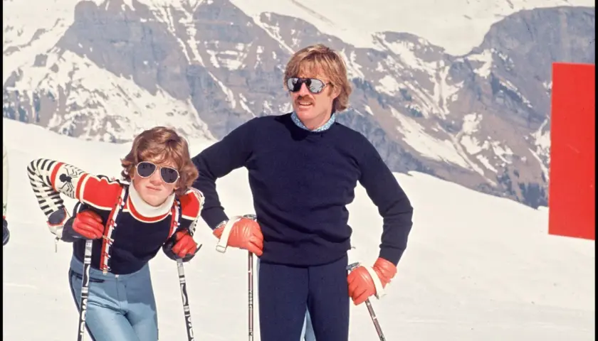 Robert Redford i jego dzieci na stoku narciarskim, w tle ośnieżone góry.