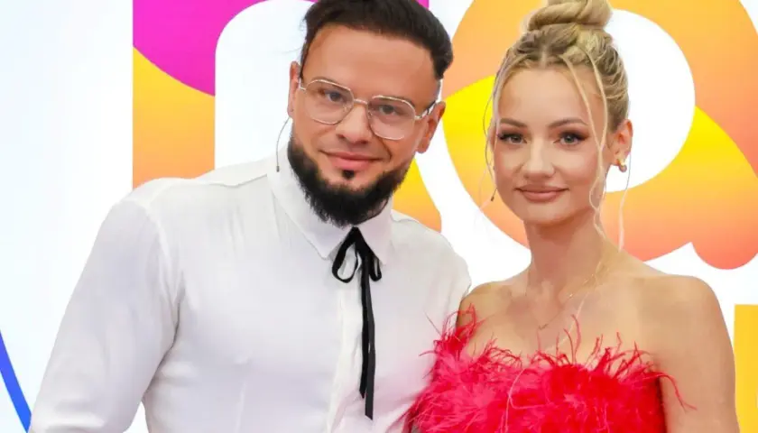 Para fit lovers, ile lat mają? Ona w różowej sukience, on w białej koszuli.