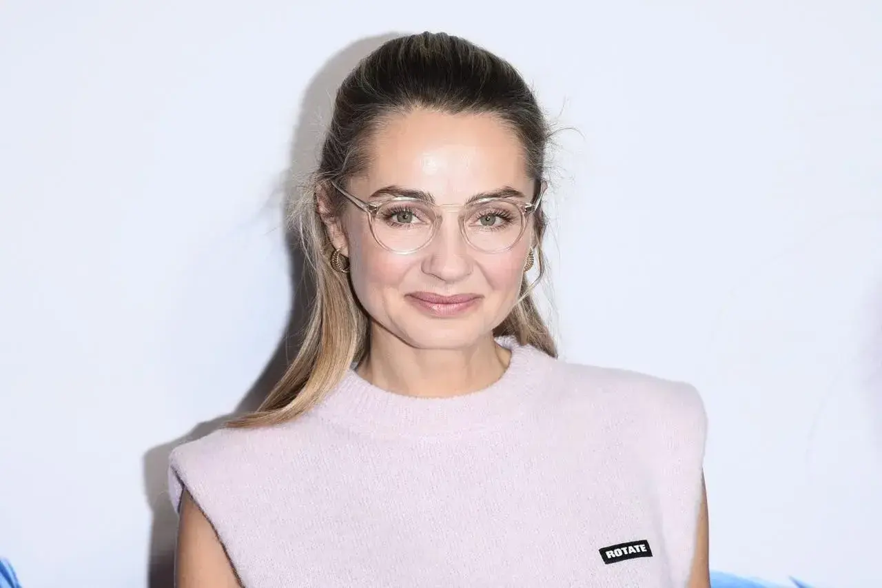 Małgorzata Socha w okularach, z subtelnym uśmiechem. Jej wiek dodaje jej uroku i doświadczenia.