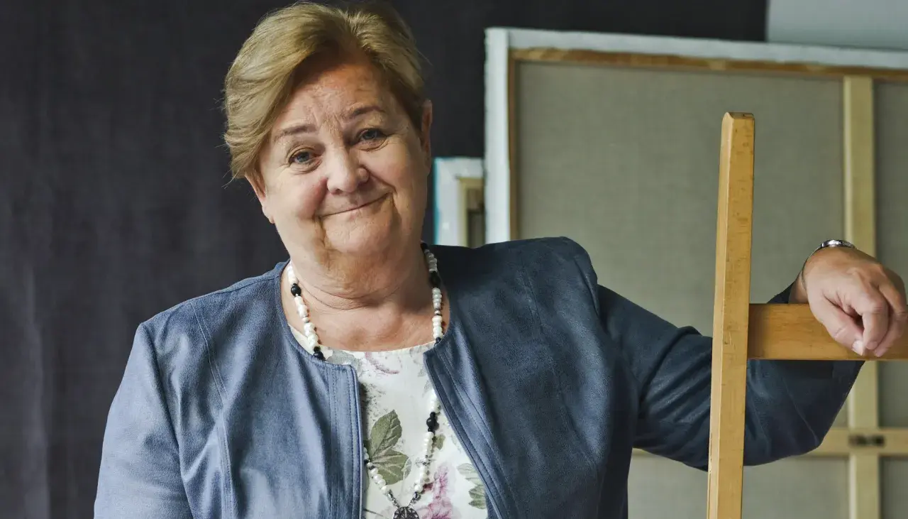 Uśmiechnięta Aleksandra Piotrowska, psycholog, opiera się o drewniane krzesło. Jej wiek jest tajemnicą, ale doświadczenie widać w oczach.