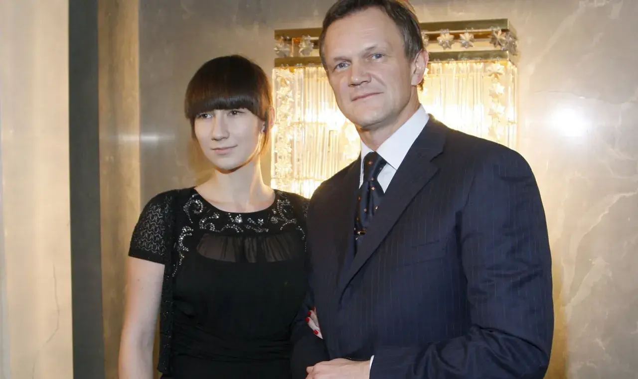 Cezary Pazura z żoną, Edytą Pazurą, pozują do zdjęcia w eleganckich strojach.
