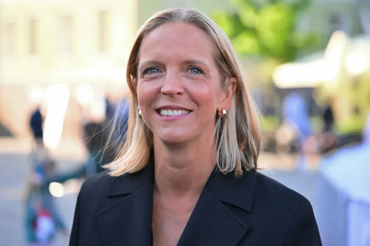 Uśmiechnięta Małgorzata Trzaskowska, której wykształcenie jest szeroko komentowane, w czarnym żakiecie.