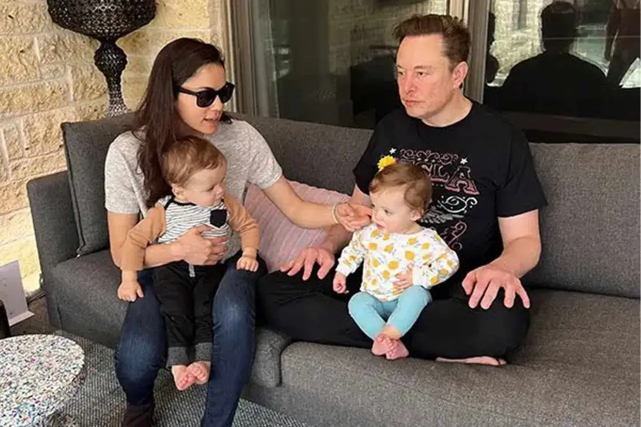 Elon Musk z żoną i dziećmi na kanapie.