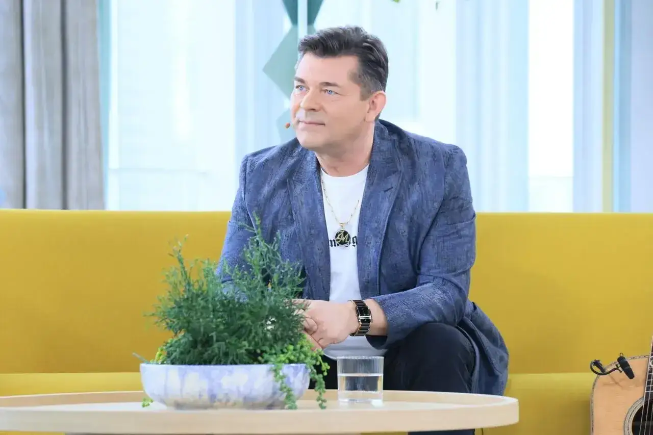 Zenek Martyniuk, zapytany ile lat ma, siedzi na kanapie w niebieskiej marynarce.