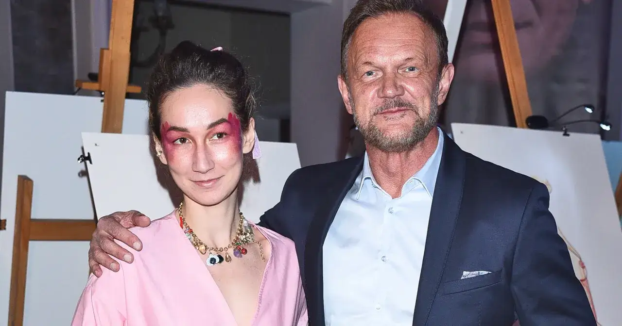 Cezary Pazura z żoną, Patrycją, na wydarzeniu. Ona w różowej sukience i z artystycznym makijażem, on w granatowym garniturze.