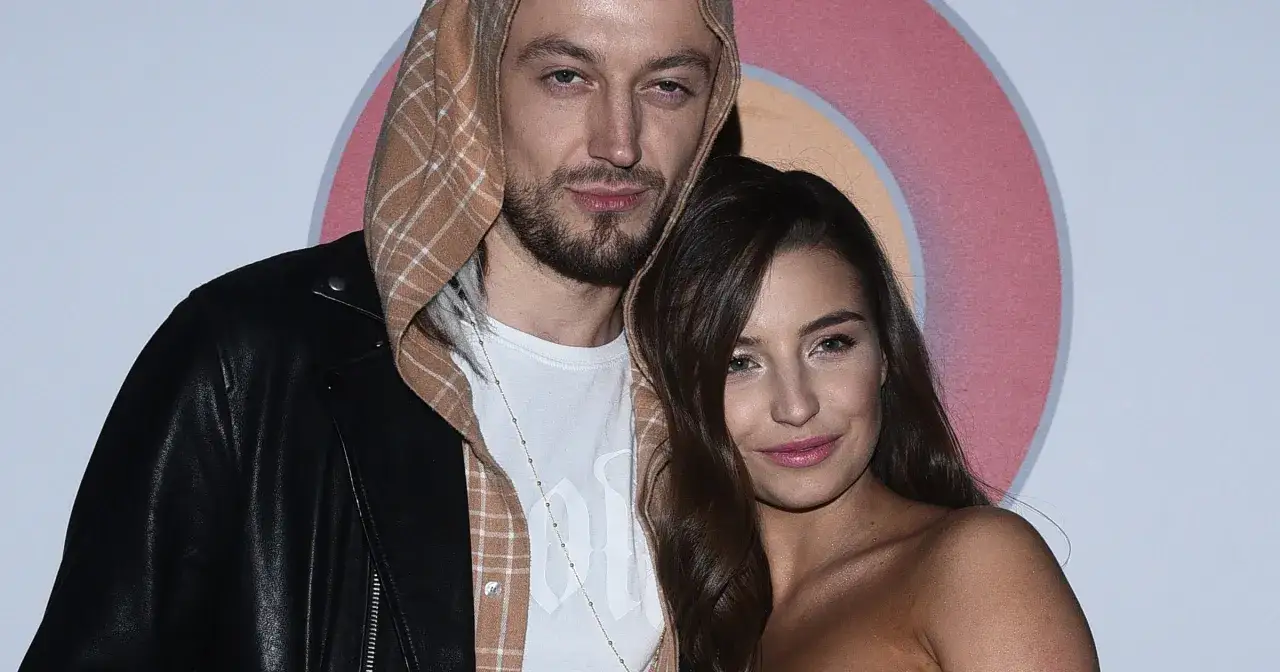 Julia Wieniawa i Baron blisko siebie, on w skórzanej kurtce i kratowanej bluzie, ona z burzą ciemnych włosów.