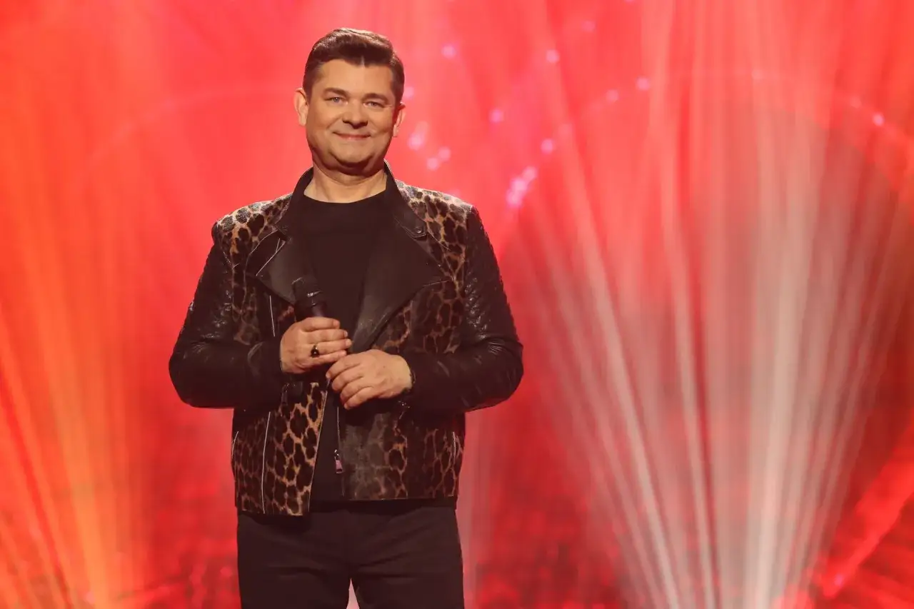 Zenek Martyniuk, w panterkowej kurtce, trzyma mikrofon. Ile lat ma Zenek Martyniuk?